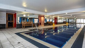 A swimming pool with a wooden bench and a sauna sign in the background.