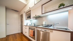 A modern kitchen with stainless steel appliances, a dishwasher, and a microwave. - Huttside - Comfortable CBD Stay near Parklands (Adelaide)