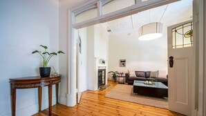 Un pasillo con piso de madera que conduce a una sala de estar con sofá y mesa de centro.