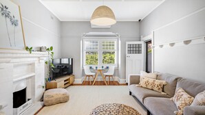 Una sala de estar con chimenea, televisor, mesa de comedor con sillas y sofá.