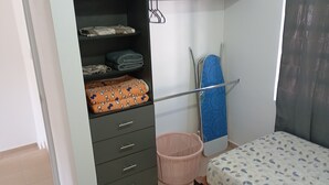 A bedroom with a bed, a wardrobe, a hanging rack, and a laundry basket. - Casa 2 recámaras zona aeropuerto clima total (Pesquería)