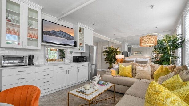 Una sala de estar moderna con sofá, mesa de centro y televisor.