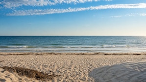 A beach with sand and sea under a partly cloudy sky. - Level Up Henley - Modern Comfort near Beach & Dining (Henley Beach)