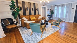 A living room with a brown leather sofa, two teal armchairs, a wooden coffee table, and a patterned rug. - Private Oasis w/ Pool, 7 min to Beach, Pool Table (Hollywood)