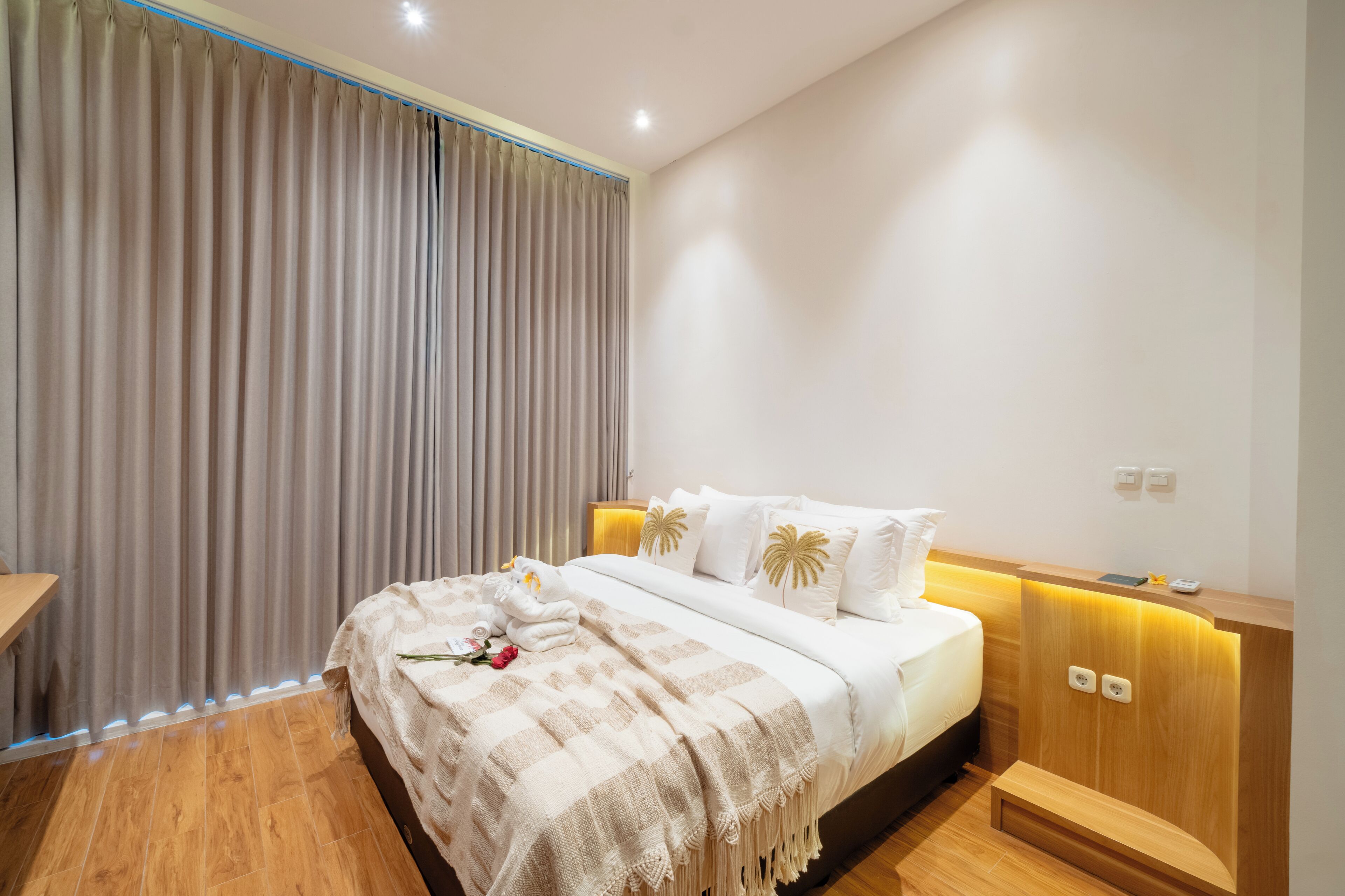 Une chambre à coucher moderne avec un lit, des tables de chevet et une tête de lit en bois.
