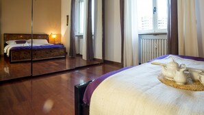 Ein Hotelzimmer mit einem großen Spiegel, der das Bett und einen Blick auf die Stadtlandschaft reflektiert.