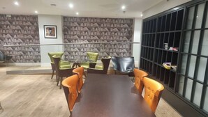 A conference room with a large table and multiple chairs, a bookshelf, and a patterned wall. - Modern Flat/Central Croydon/Sleeps 4/Free Parking (Croydon)