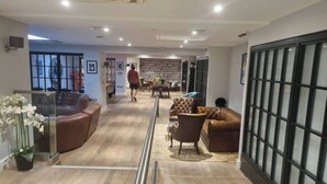 A spacious living area with a wooden floor, leather sofas, and a glass partition. - Modern Flat/Central Croydon/Sleeps 4/Free Parking (Croydon)