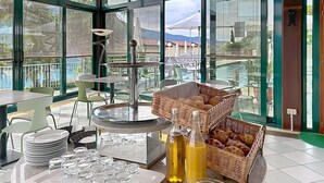 A breakfast setup with a buffet table, wicker baskets, and a view of the outdoors. - Cosy apartment for 2 guests with pool, WIFI, TV and terrace (Pieve)