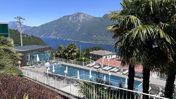 A pool area with lounge chairs and a view of the sea and mountains. - Cosy apartment for 2 guests with pool, WIFI, TV and terrace (Pieve)