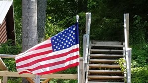 Una escalera de madera con una bandera estadounidense a la izquierda.
