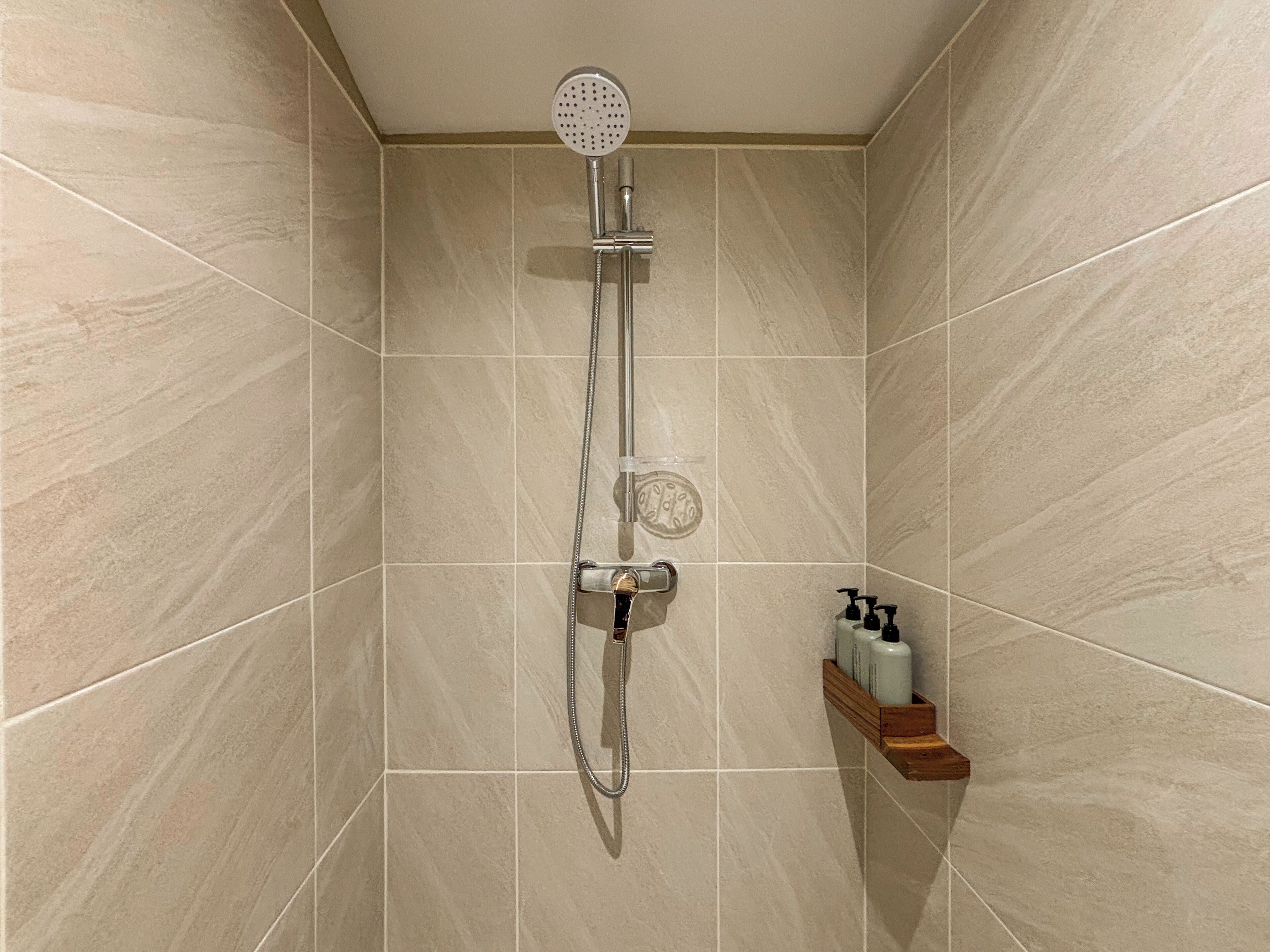 A shower with a handheld showerhead and a handheld shower attachment.