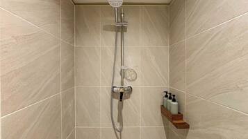 A shower with a handheld showerhead and a handheld shower attachment.