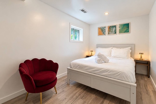 Inviting second bedroom with full-size bed, fresh linens & cozy accent chair.