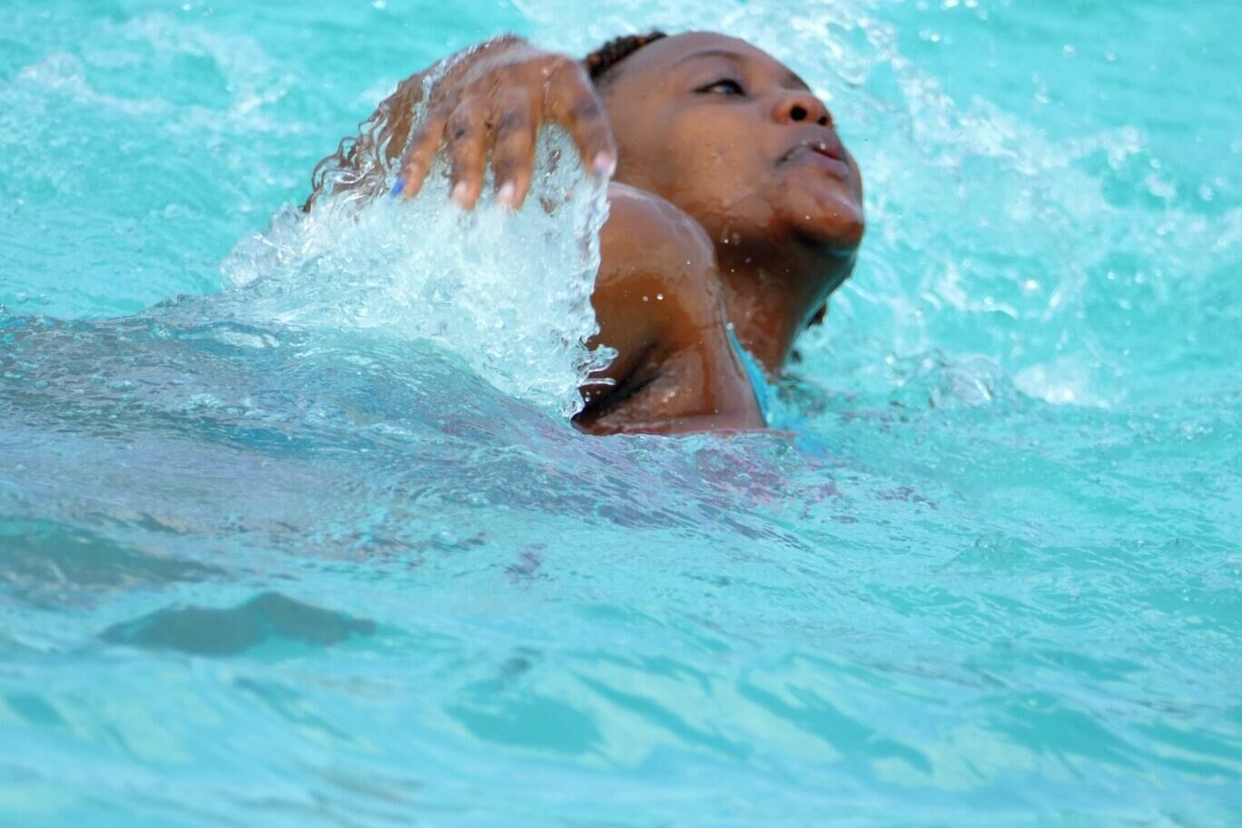 A person swimming in clear blue water.