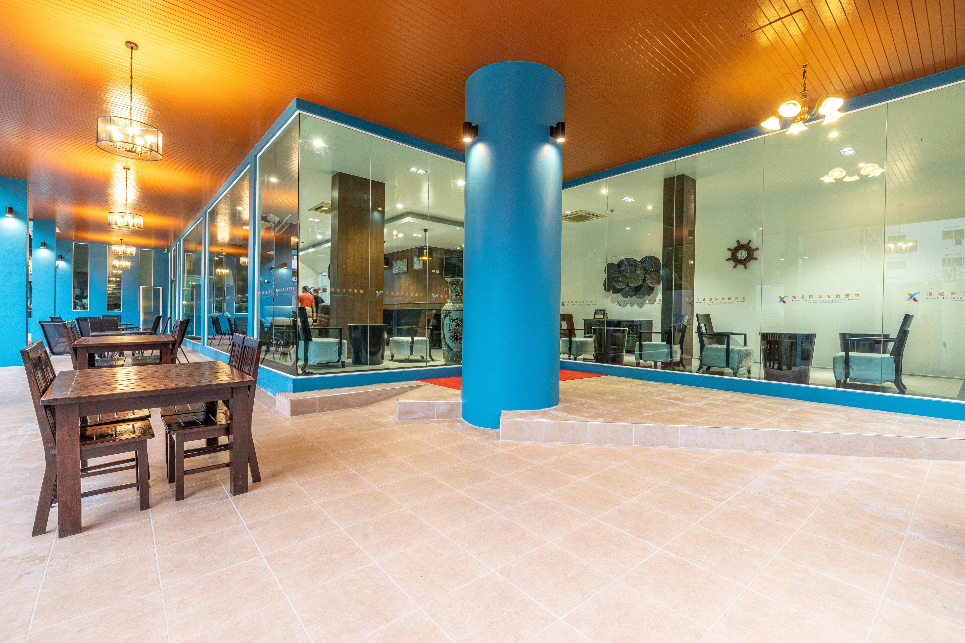 A modern interior with a wooden ceiling, glass walls, and a blue accent pillar.