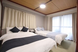 A hotel room with two beds, a wooden ceiling, and large windows with curtains. - LUANA HOTEL IKEBUKURO HIGASHINAGASAKI (Tokyo)