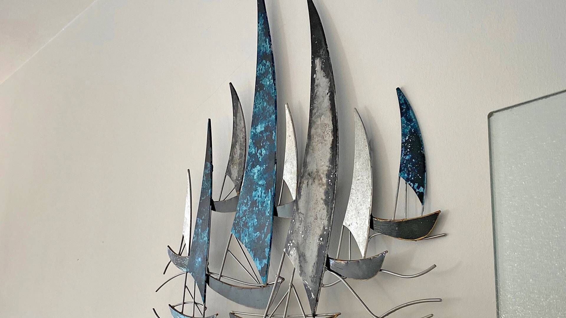 A metal sculpture with abstract shapes and a reflective surface.