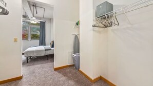 Ein kleines Zimmer mit Bett, Heizkörper und Wäscheständer.