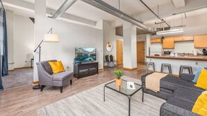 A modern apartment with a living room, kitchen, and dining area.