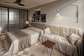 A modern bedroom with a large bed, a sofa, a small table, and a ceiling fan. - A Stay In Bàu Vá (Hue)