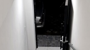 Un escalier aux marches en marbre blanc menant à une pièce sombre.