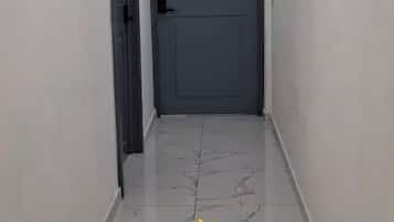 Un pasillo con una puerta cerrada marcada con una 'B' y un gráfico de girasol con el texto de bienvenida a The Bello Lodging.
