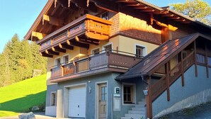 A two-story building with a balcony, a garage, and a staircase. - Detached holiday home with terrace and balcony. (Bramberg am Wildkogel)