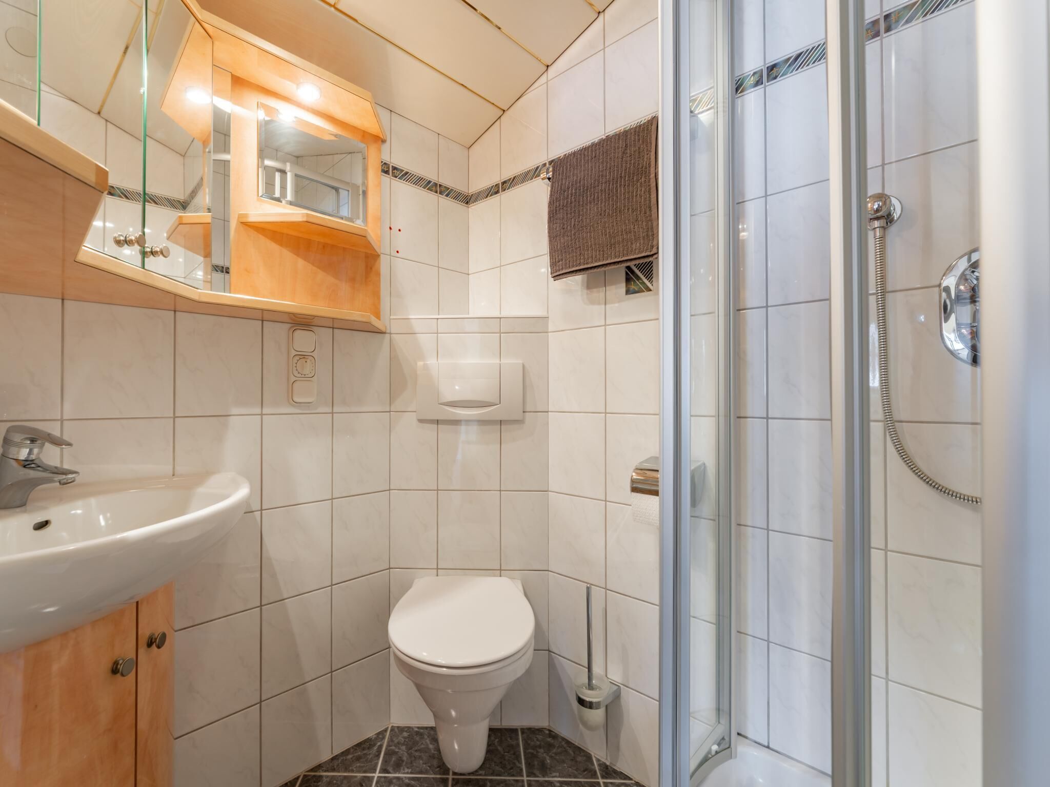 A modern bathroom with a sink, toilet, and glass-enclosed shower.