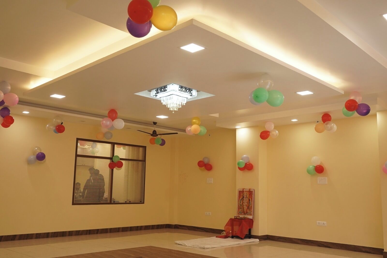 Una habitación amplia con techo alto, iluminación empotrada y candelabro.