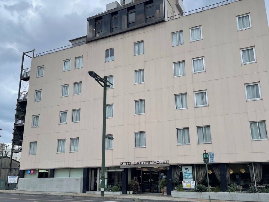 A multi-story hotel with a flat facade, numerous windows, and a sign reading "Mitsu Daiichi Hotel".