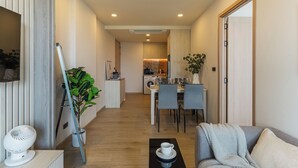 Un appartement moderne comprenant un coin repas, une cuisine et un salon.