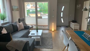 Ein modernes Wohnzimmer mit Sofa, Couchtisch und Essbereich.