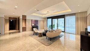 A modern hotel room with a spacious layout, a large window offering a view of the outdoors, a seating area with a coffee table, and a flat-screen TV on a stand. - Act 1 Act 2 Towers by DVH Luxe Retreats (Dubai)