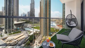 A balcony with a view of a cityscape, including tall buildings and a body of water. - Act 1 Act 2 Towers by DVH Luxe Retreats (Dubai)