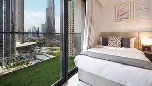A modern hotel room with a large bed, a view of a cityscape, and a balcony with a pool. - Act 1 Act 2 Towers by DVH Luxe Retreats (Dubai)