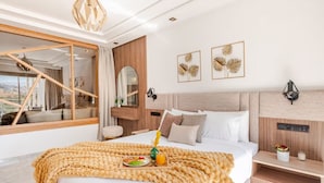 Een moderne hotelkamer met een groot bed, een houten hoofdeinde en uitzicht door een glazen deur.