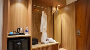A modern bathroom with wooden paneling, a shower area, a towel rack, and a small table with a kettle and bottles. - THE ELET (Amritsar)