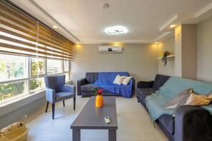 Condo superluxo, 1 cama Queen e sofá-cama, banheiro privativo, vista para o mar | Área de estar | Smart TV 32 polegadas com canais via satélite