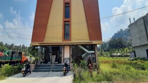 A building with a modern design, featuring a central vertical window and a staircase leading to the entrance. - All Season Residency (Port Blair)