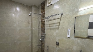 A bathroom with a shower, toilet, sink, and a yellow bucket. - All Season Residency (Port Blair)