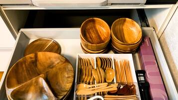 A drawer with wooden bowls, spoons, and a box.