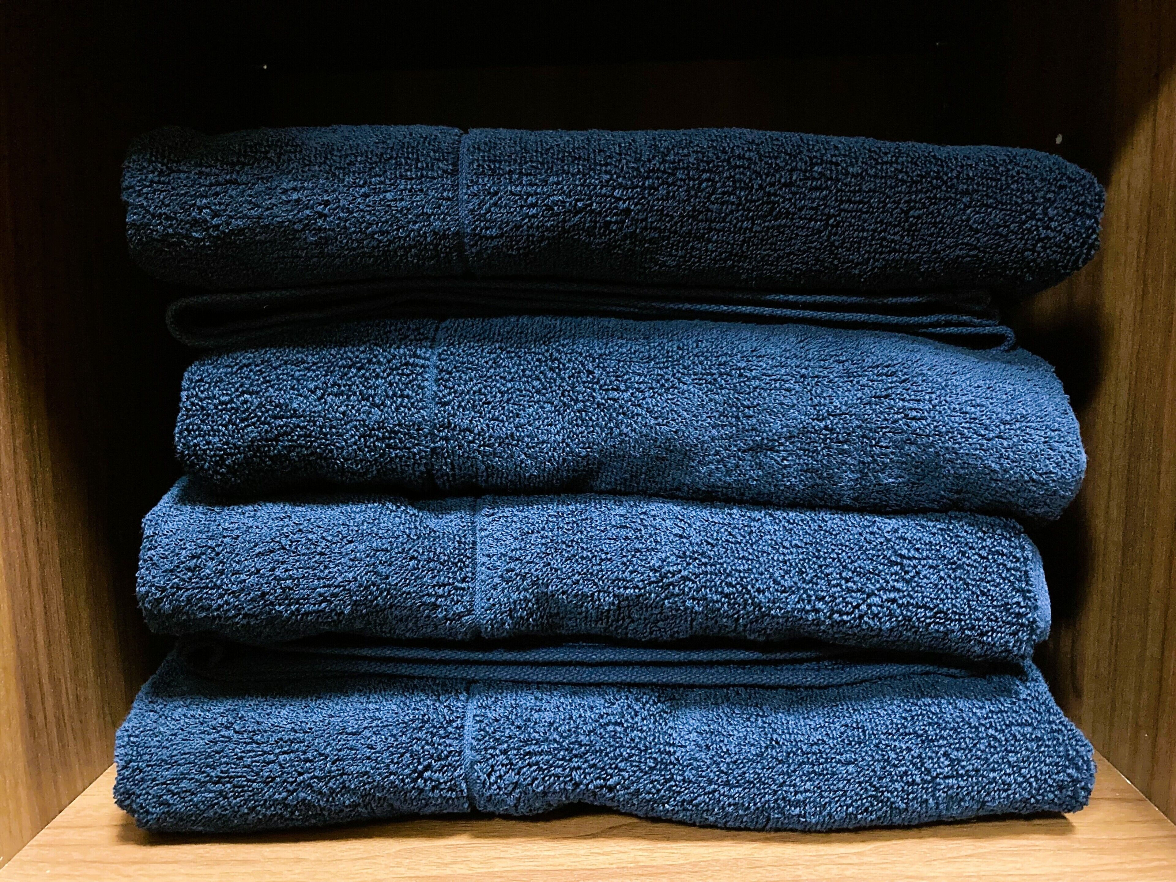 Une pile de serviettes pliées dans un meuble en bois.