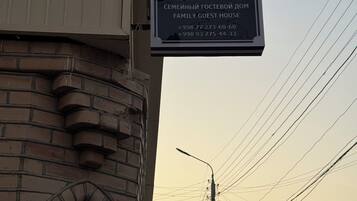 A sign for a family guest house with contact numbers.