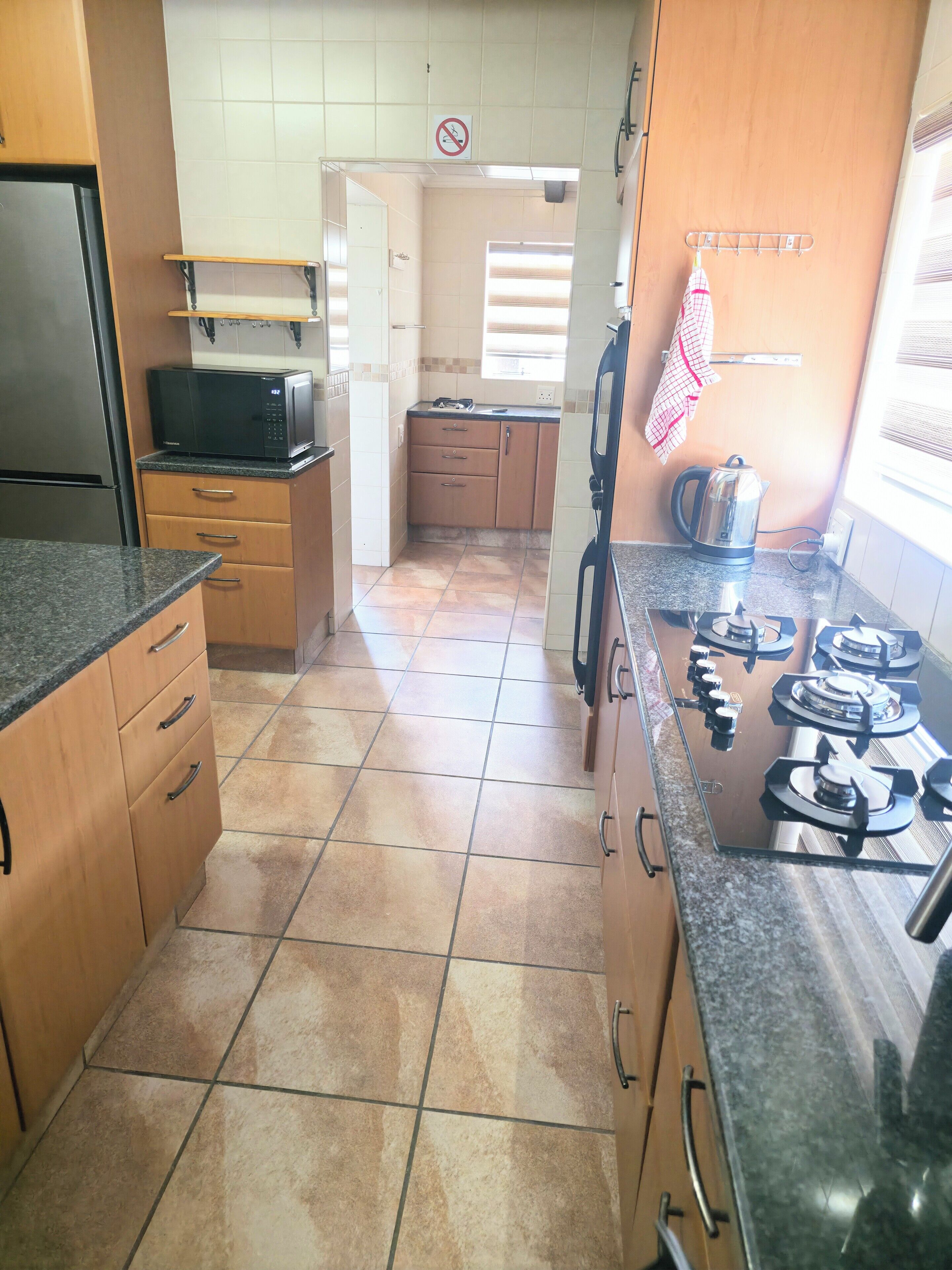 Una cocina equipada con estufa, microondas y refrigerador.