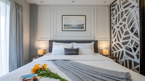 A neatly made bed with a pillow labeled "3D CHAMBERS," a bedside lamp, a framed picture on the wall, and a window with curtains. - Bedchambers Apart hotel Sec 39 (Gurugram)