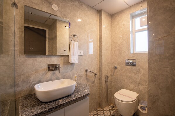Une salle de bain moderne avec un grand lavabo, des toilettes et une douche.
