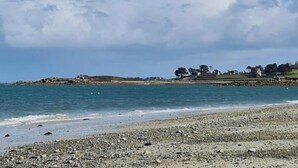 Une plage de galets avec une mer calme.