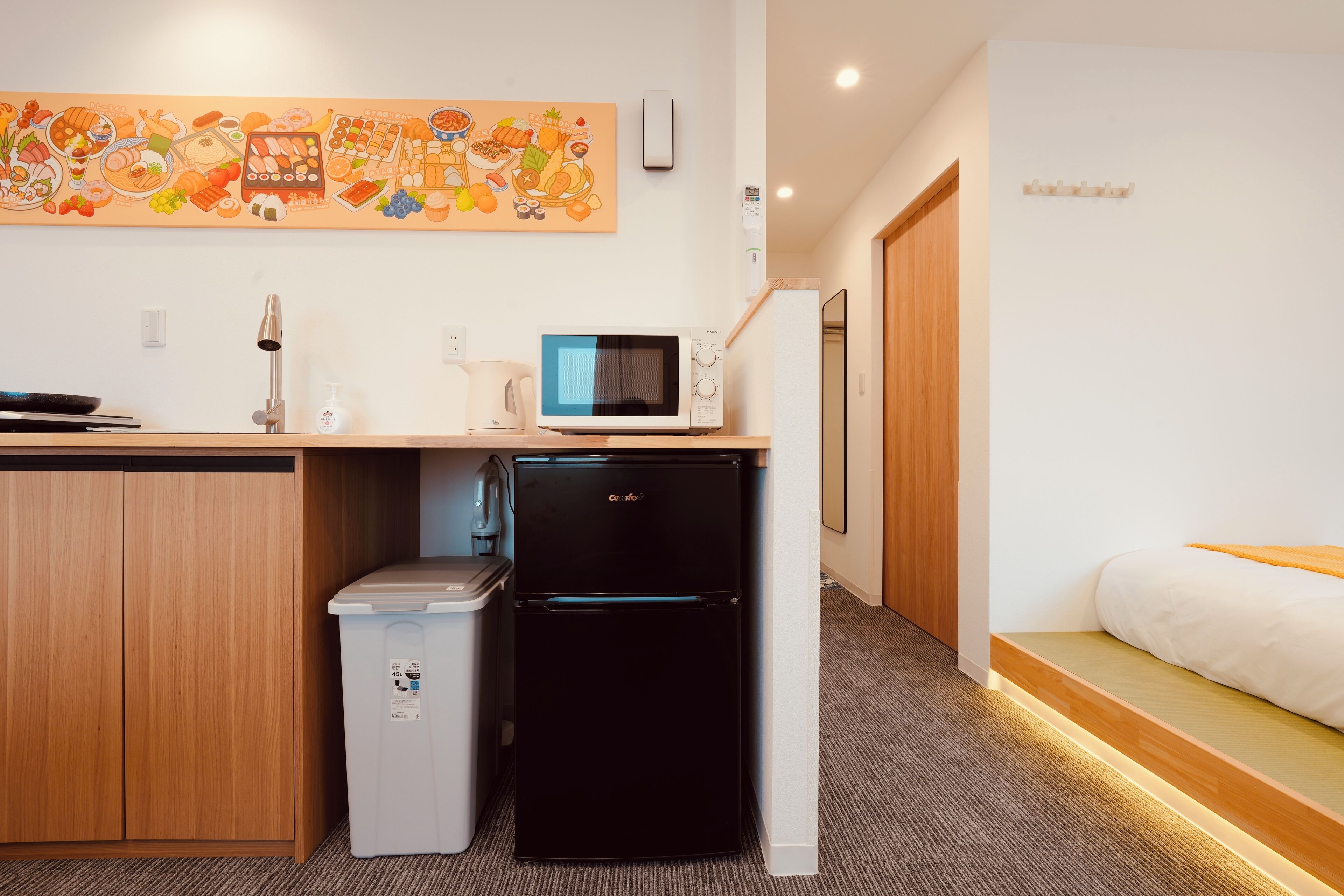 A compact kitchenette with a microwave, refrigerator, and sink.