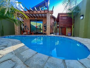 A swimming pool with a tiled edge, surrounded by a patio area with stone flooring. - Twalumba Resort Village (Lusaka)